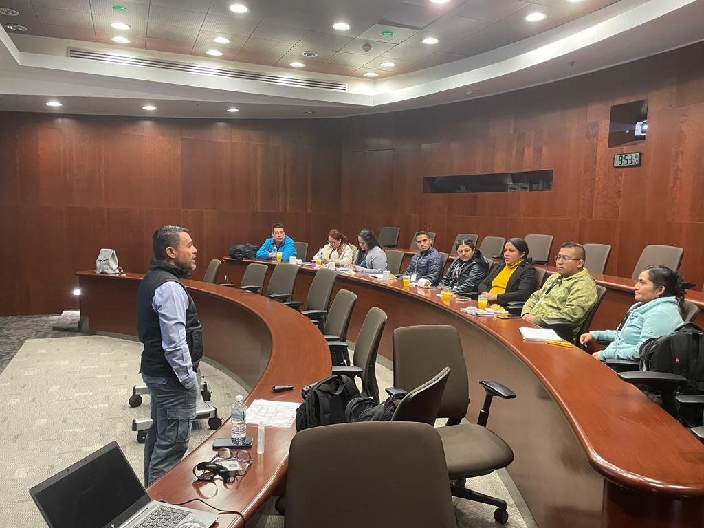 Roy Sosa impartiendo una capacitación a un grupo de participantes en un auditorio