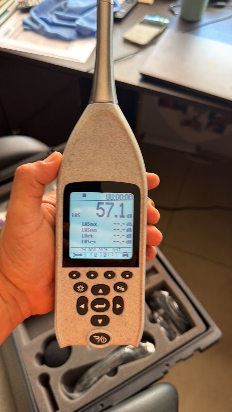 Sonómetro mostrando una lectura de 57,1 dB durante una medición de ruido